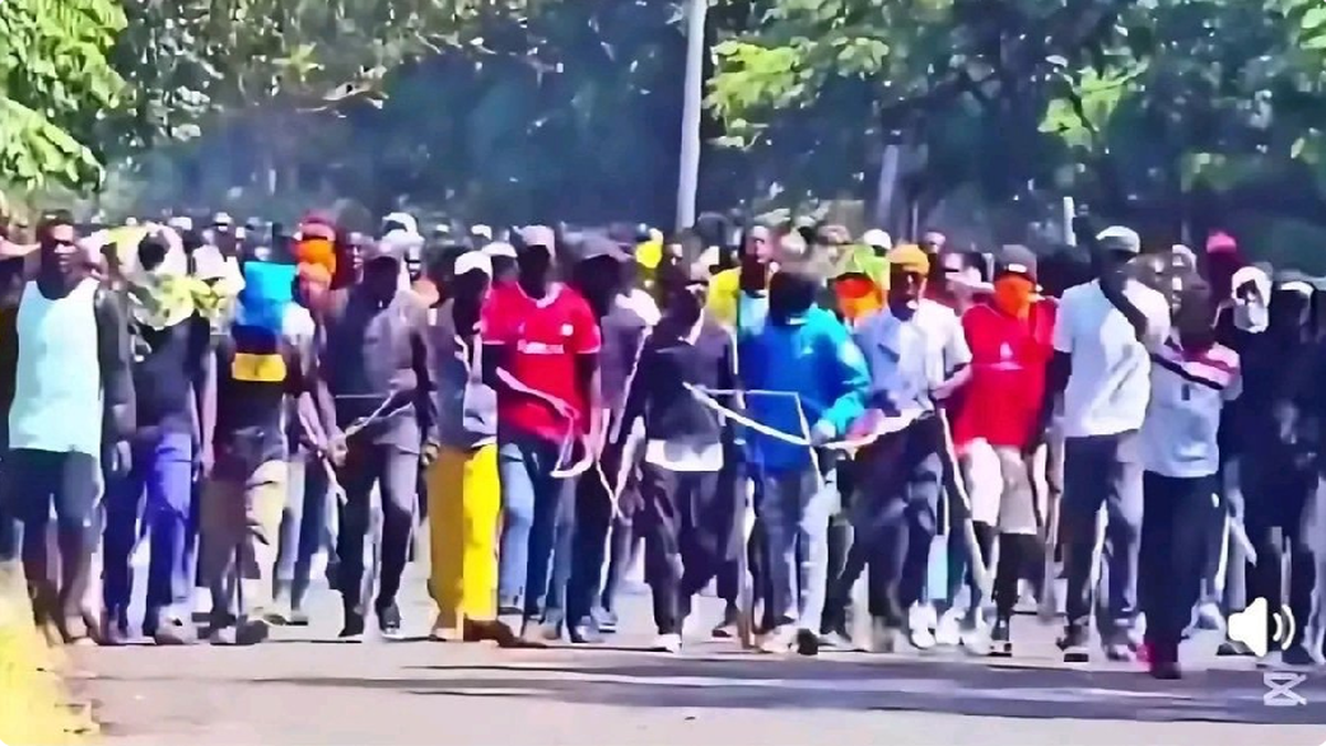 Crowd of young men carrying sticks during public disorder
