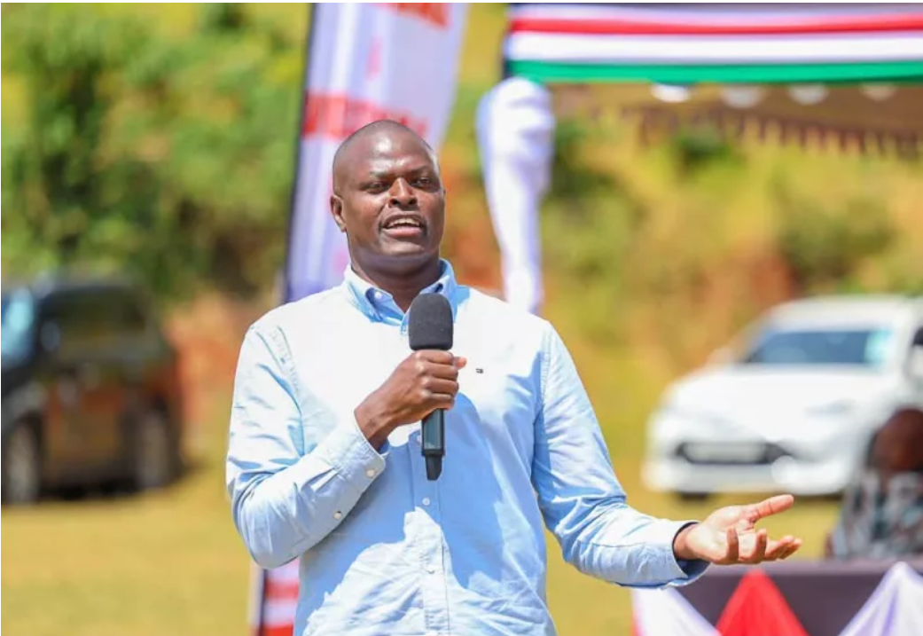Ndindi Nyoro speaking into a microphone at an outdoor event